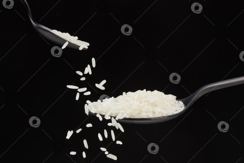 Скачать Рисовые зерна в ложке на черном фоне. фотосток Ozero