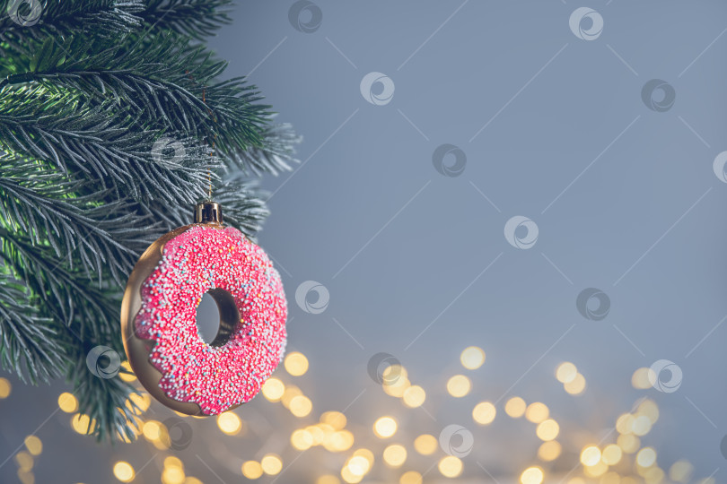 Скачать новогодняя игрушка в виде розового пончика на рождественской елке фотосток Ozero