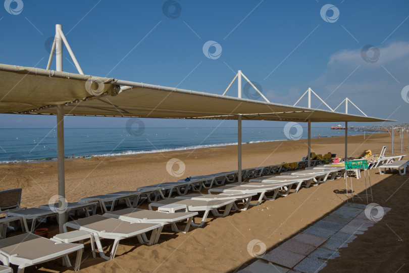 Скачать Пляж с шезлонгами под навесами на берегу моря. фотосток Ozero