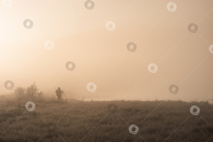 Скачать Силуэт фотографа со штативом в тумане. фотосток Ozero