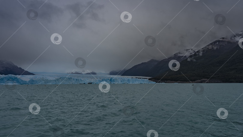 Скачать Стена из голубого льда пересекает бирюзовое ледниковое озеро. фотосток Ozero