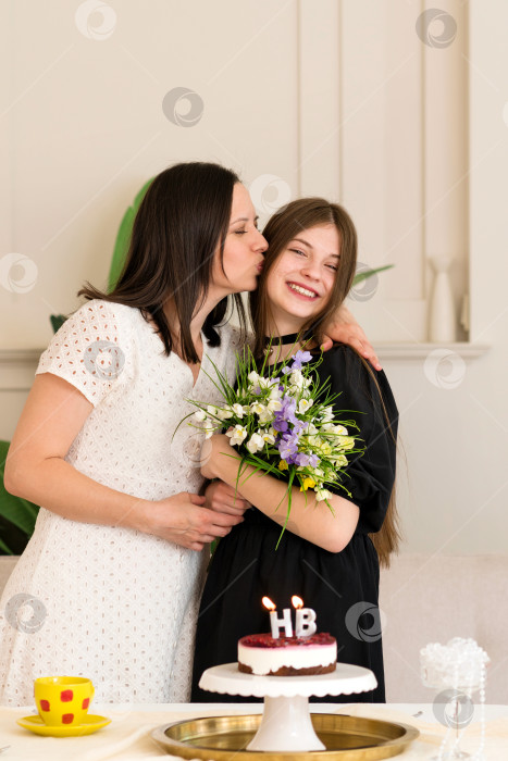 Скачать Мать целует дочь на праздновании дня рождения с тортом. фотосток Ozero