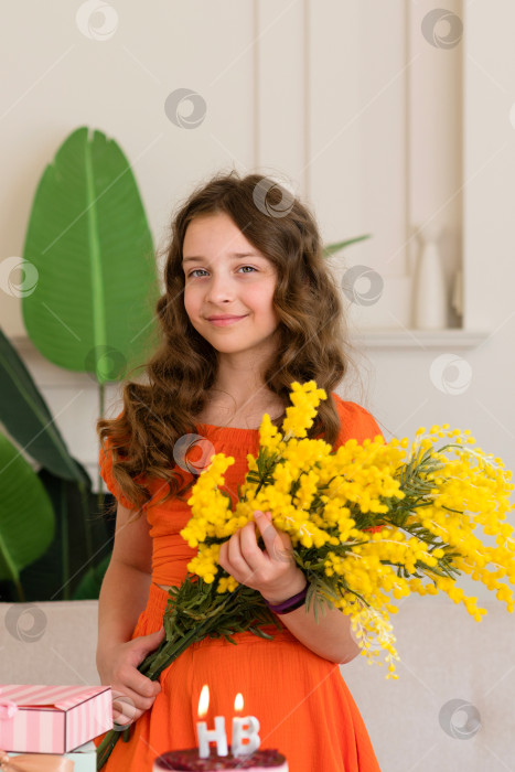 Скачать Девушка в оранжевом платье держит в руках желтые цветы фотосток Ozero