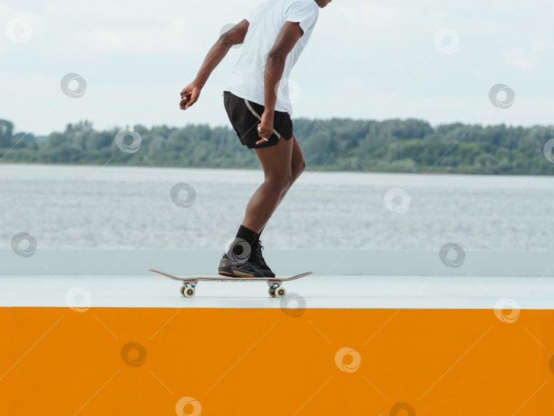 Скачать Неузнаваемый африканский фигурист катается на скейтборде фотосток Ozero