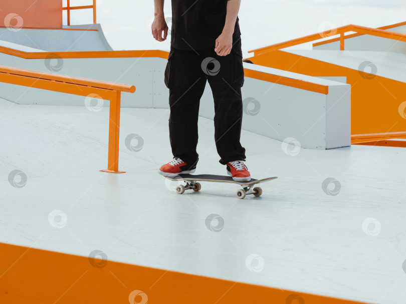 Скачать Фигурист на скейтборде катается на коньках в скейт-парке на открытом воздухе. фотосток Ozero