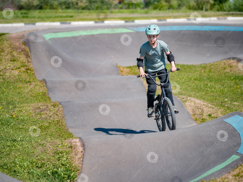 Скачать Памп-трек. Ребенок на велосипеде bmx катается по памп-треку. фотосток Ozero