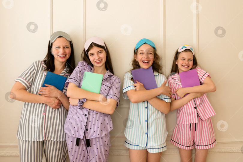 Скачать Woman and group girls in striped pajamas holding books фотосток Ozero