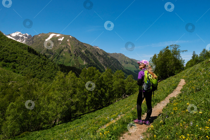 Скачать Девушка, идущая пешком по горной тропе с живописным видом. фотосток Ozero