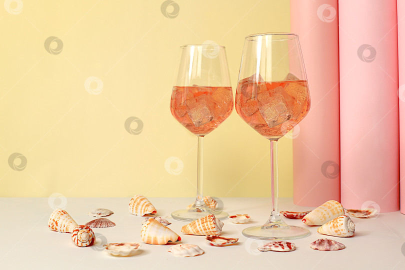 Скачать Современный летний натюрморт с алкогольным коктейлем Aperol spritz, шампанским и ракушками на элегантном современном фоне, минималистичная концепция для бара и праздничной вечеринки, кафе, рекламный баннер, селективный акцент фотосток Ozero