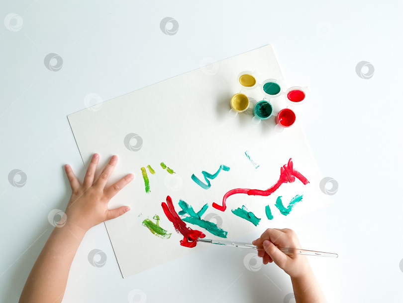 Скачать маленький ребенок рисует красками и кисточкой на белом столе. день отцов фотосток Ozero