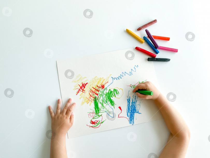 Скачать маленький ребенок рисует пастельными мелками на белом столе. день отцов фотосток Ozero