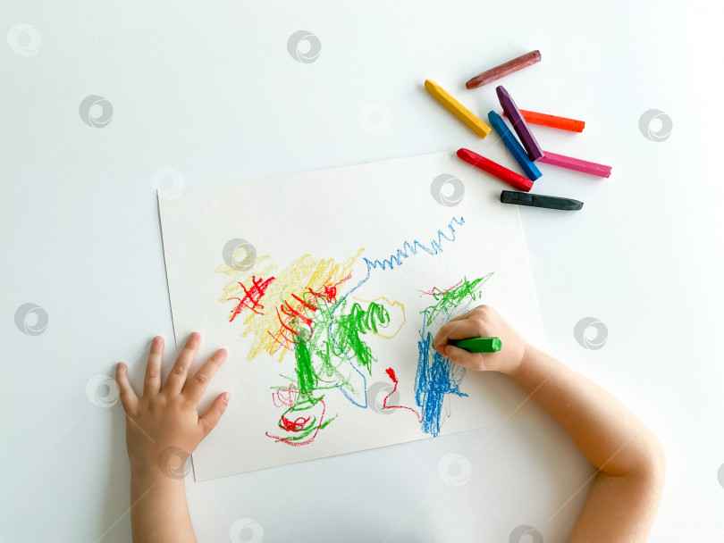 Скачать маленький ребенок рисует пастельными мелками на белом столе. день отцов фотосток Ozero