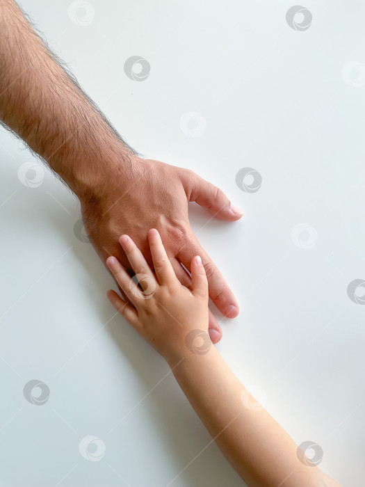 Скачать Взрослый и ребенок держатся за руки вместе. В День отцов ребенок протягивает руку взрослому фотосток Ozero