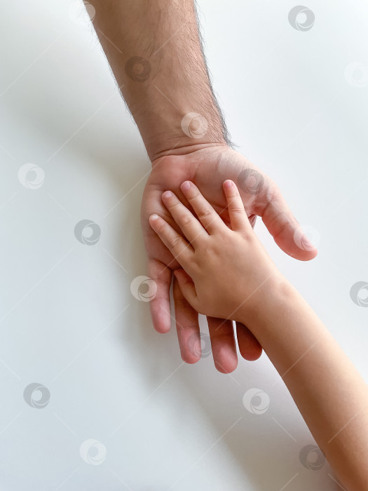 Скачать Взрослый и ребенок держатся за руки вместе. В День отцов ребенок протягивает руку взрослому фотосток Ozero