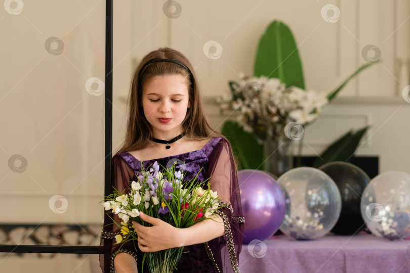 Скачать Девушка смотрит на букет цветов на вечеринке по случаю дня рождения. фотосток Ozero