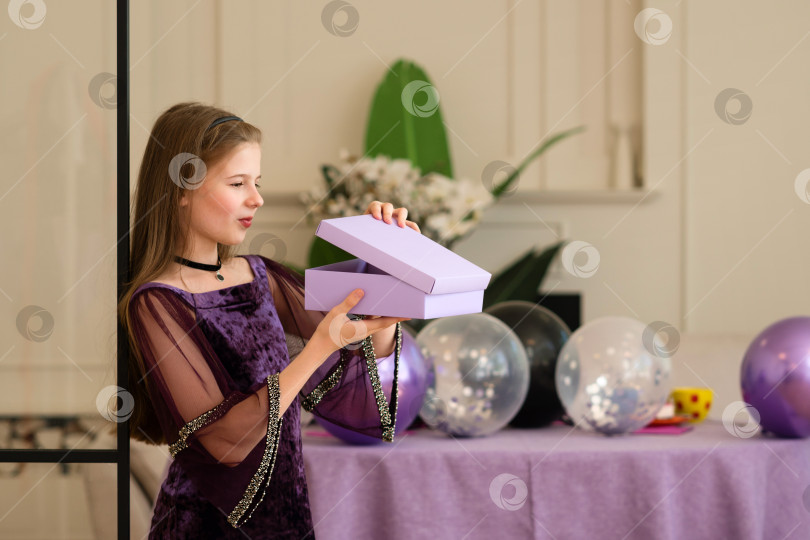 Скачать Девушка открывает подарочную коробку на вечеринке по случаю дня рождения с воздушными шарами фотосток Ozero