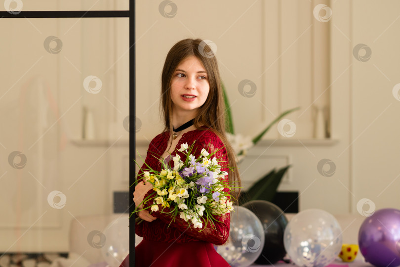 Скачать Девушка-подросток в красном кружевном платье держит в руках букет цветов фотосток Ozero
