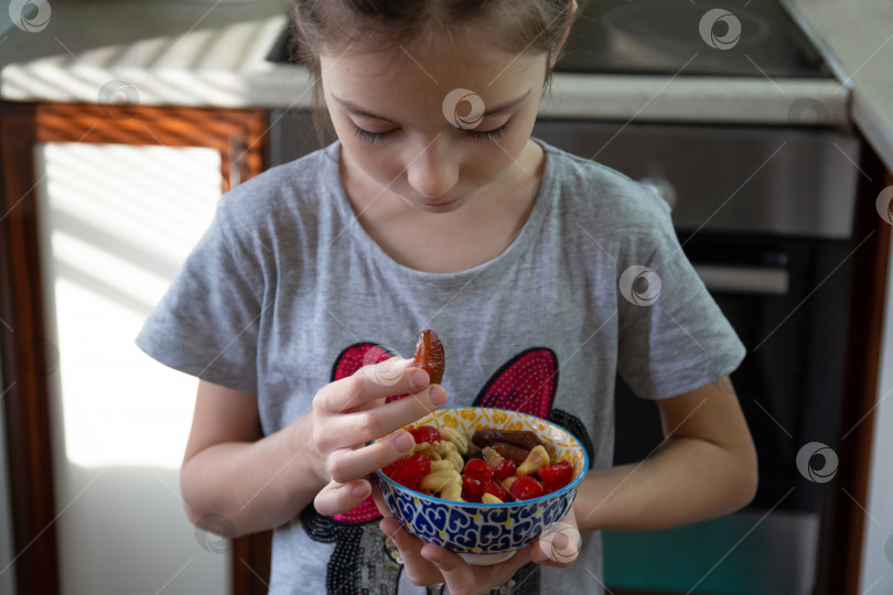 Скачать Девушка ест сухофрукты дома фотосток Ozero