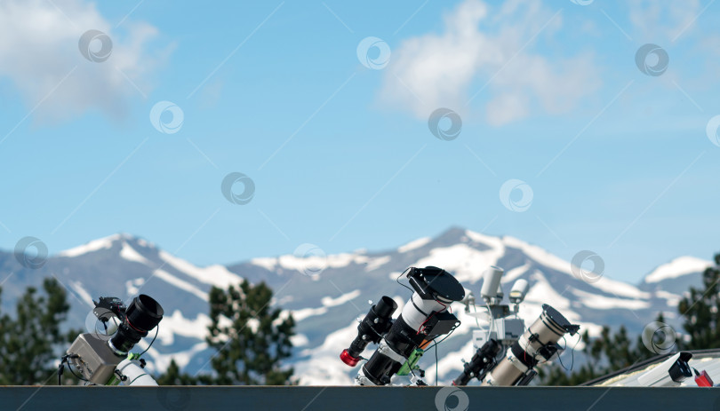 Скачать Телескопы на крыше с заснеженными горами на заднем плане. фотосток Ozero