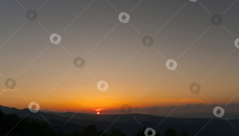 Скачать Золотой закат над горами при ясном небе. фотосток Ozero