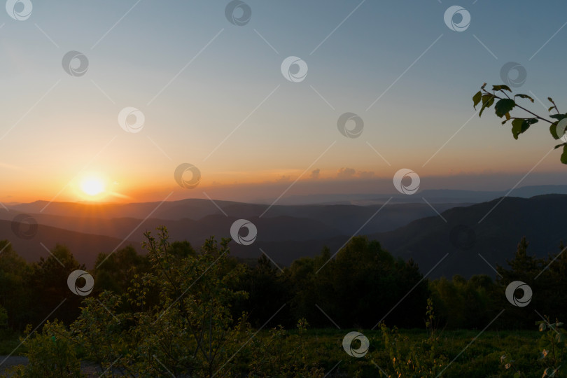Скачать Золотой закат над холмами и лесами при ясном небе. фотосток Ozero