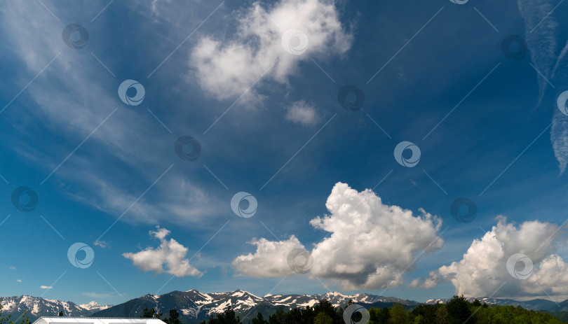 Скачать Заснеженные горы под переменно облачным небом. фотосток Ozero