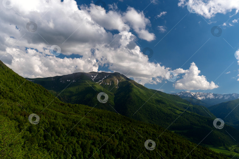 Скачать Горный хребет с пышными зелеными склонами и голубым небом фотосток Ozero
