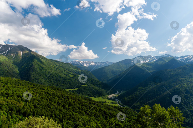 Скачать Горная долина с пышными зелеными холмами и заснеженными вершинами фотосток Ozero