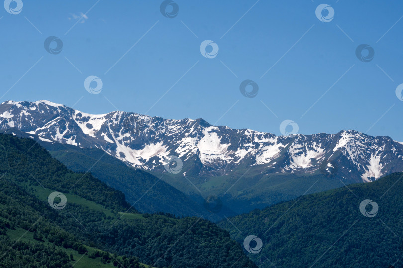 Скачать Заснеженный горный хребет под ясным голубым небом. фотосток Ozero