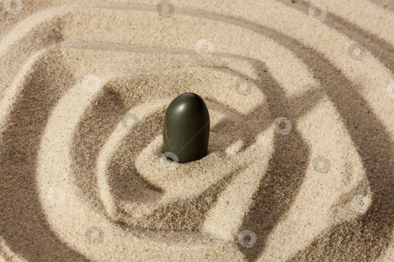 Скачать Черный камень, торчащий из песка фотосток Ozero