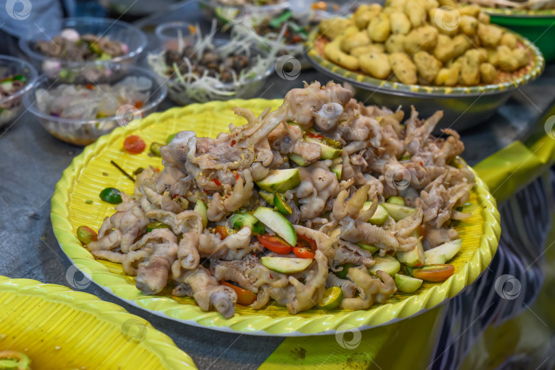 Скачать Любимая вьетнамская закуска - тушеная куриная лапка в соусе чили на вьетнамском ночном рынке во время фестиваля еды фотосток Ozero