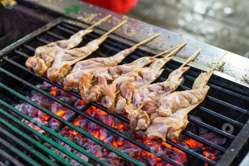 Скачать Сырые куриные крылышки для барбекю на гриле в Jalan Alor street food в Куала-Лумпуре фотосток Ozero