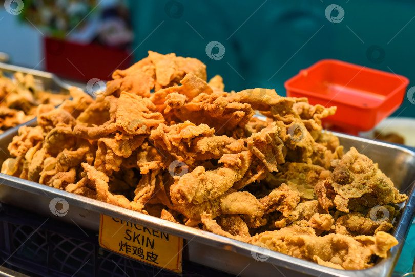 Скачать Жареная куриная шкурка в уличном ресторане Jalan Alor в Куала-Лумпуре фотосток Ozero