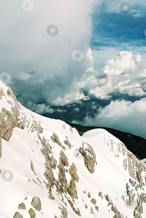 Скачать Заснеженные горы, голубое небо и густые облака. Легкая и воздушная картина. фотосток Ozero