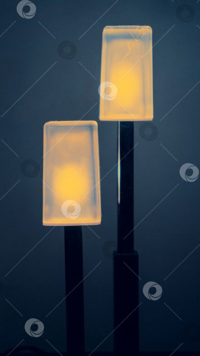 Скачать Лампа представляет собой ночник на черной подставке. Прямоугольные плафоны с желтым теплым светом. Мягкая избирательная фокусировка фотосток Ozero
