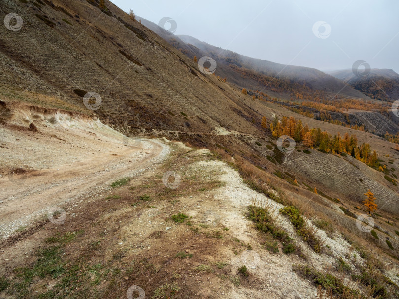 Скачать Пустая опасная узкая горная дорога на склоне утеса. фотосток Ozero