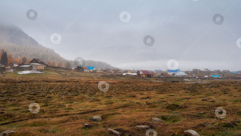 Скачать Маленькая деревушка у подножия горы. Золотой осенний пейзаж фотосток Ozero