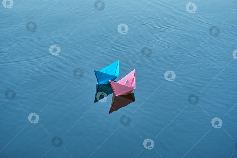 Скачать Две лодки голубого и розового цветов плывут по реке. Летний день, отдых на пруду фотосток Ozero