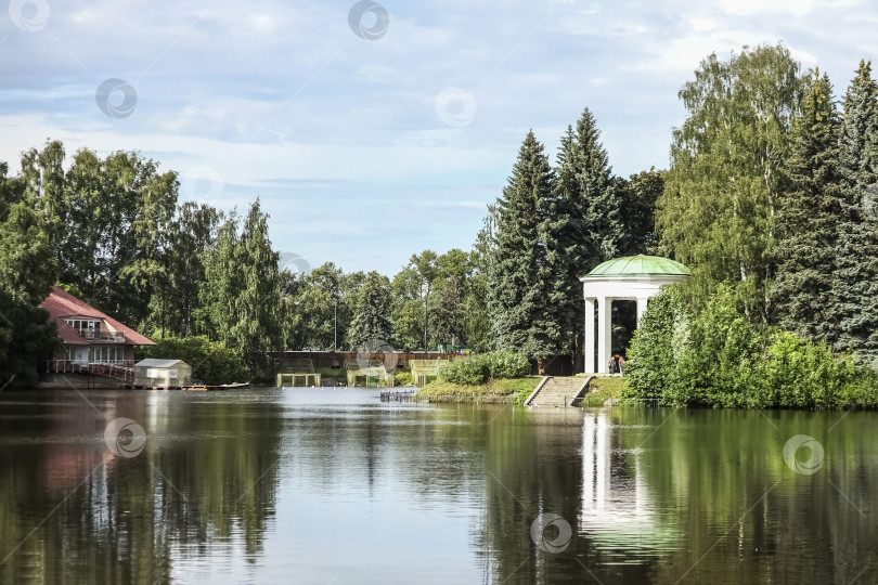 Скачать Берег озера в парке. Отражение домов в воде. Экология, охрана окружающей среды фотосток Ozero