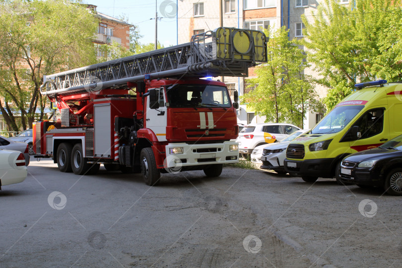 Скачать Пожарная машина и машина скорой помощи во дворе жилого дома фотосток Ozero