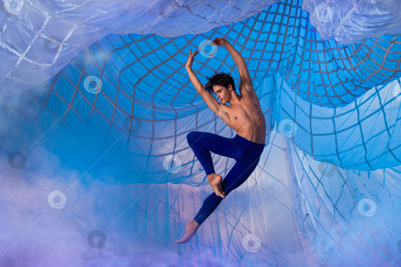Скачать Мужчина в синих штанах танцует в воздухе. фотосток Ozero