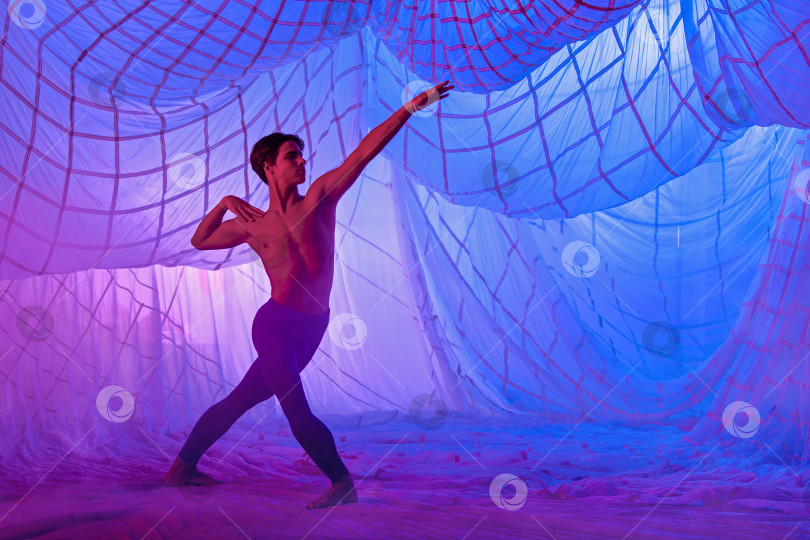 Скачать Мужчина в синем костюме танцует балет на синем фоне. фотосток Ozero