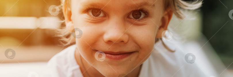 Скачать портретное лицо милого маленького счастливого улыбающегося искреннего пятилетнего мальчика с большими глазами и длинными светлыми волосами в белой футболке. поколение z дети психическое здоровье образ жизни и психология разума фотосток Ozero