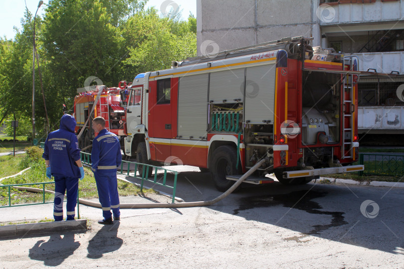 Скачать Сотрудники скорой помощи около пожарной машины во время тушения пожара фотосток Ozero