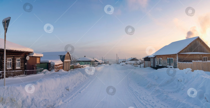 Скачать Зимняя дорога через заснеженную деревню, сильный мороз фотосток Ozero