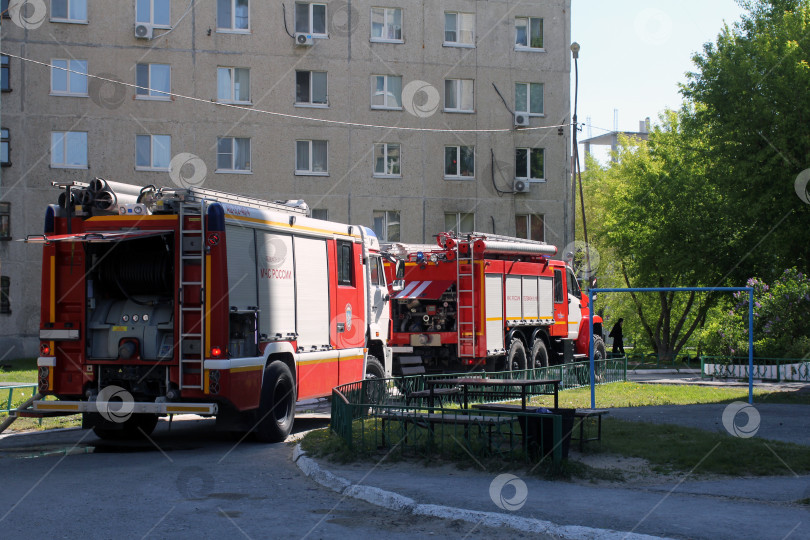 Скачать Пожарные машины пожарного расчета во дворе жилого дома фотосток Ozero