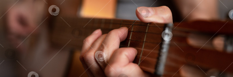 Скачать мужские руки пожилого пожилого кавказца, держащего классическую гитару и играющего на ней крупным планом дома. непрофессиональные безликие гитаристы играют любительскую музыку. домашние хобби и досуг фотосток Ozero