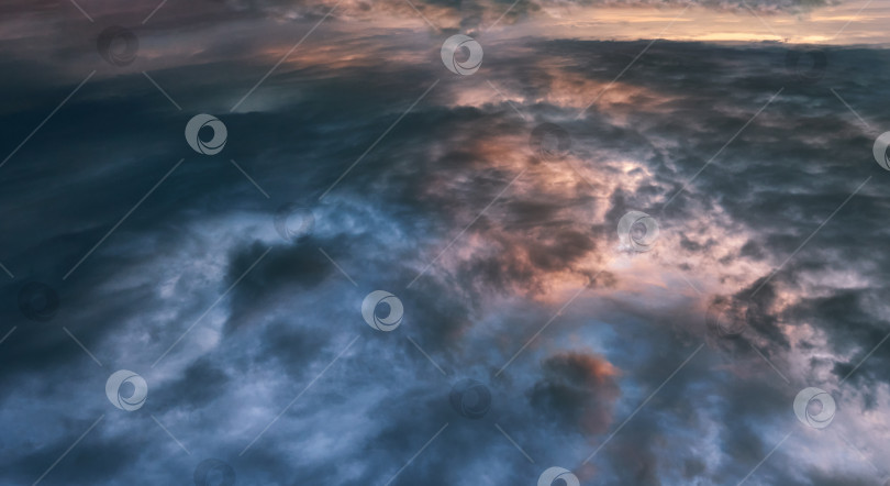 Скачать Плотные голубые облака на закате. Естественные красочные солнечные лучи. Естественный вечерний закат и густые синие облака. Вид на облачное небо из космоса фотосток Ozero
