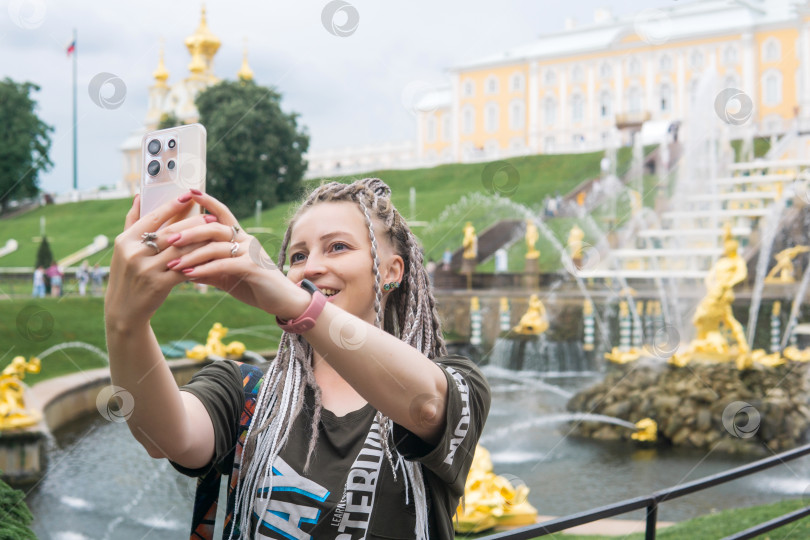 Скачать турист делает селфи перед Большим каскадом в дворцовом парке Петергоф, Санкт-Петербург фотосток Ozero