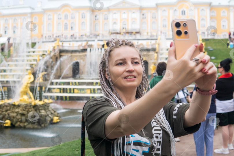 Скачать турист делает селфи перед Большим каскадом в дворцовом парке Петергоф, Санкт-Петербург фотосток Ozero